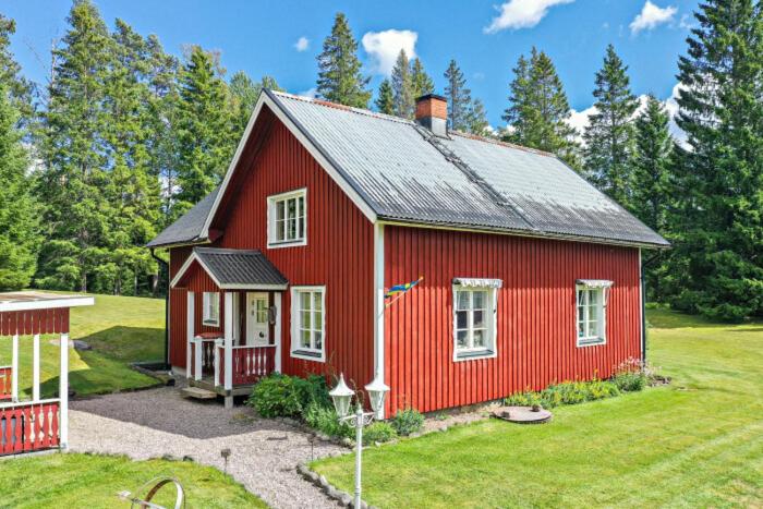 schwedischer Waldhof -Marie- in einsamer Lage في آمال: منزل احمر بسقف اسود على ساحة