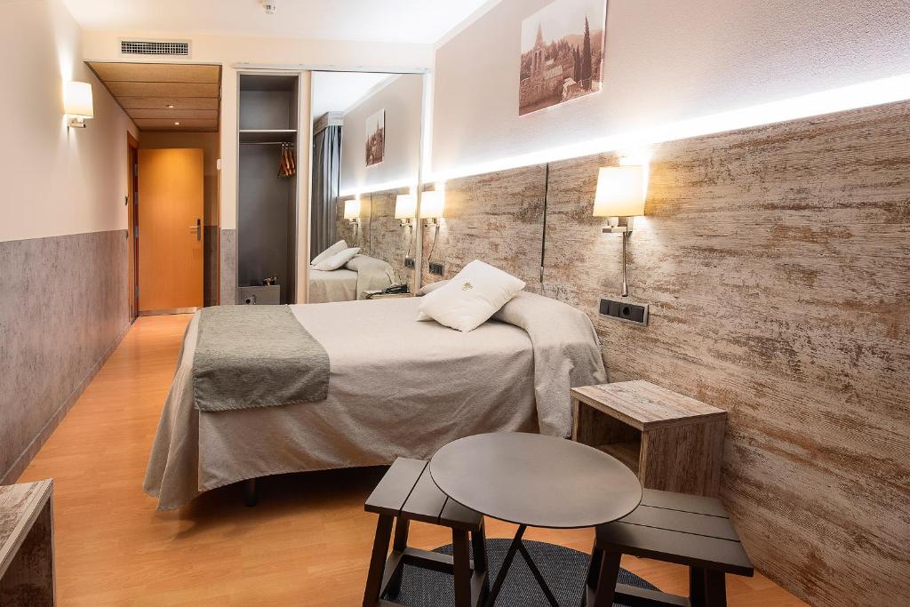 Postel nebo postele na pokoji v ubytování Hotel Palau de Girona