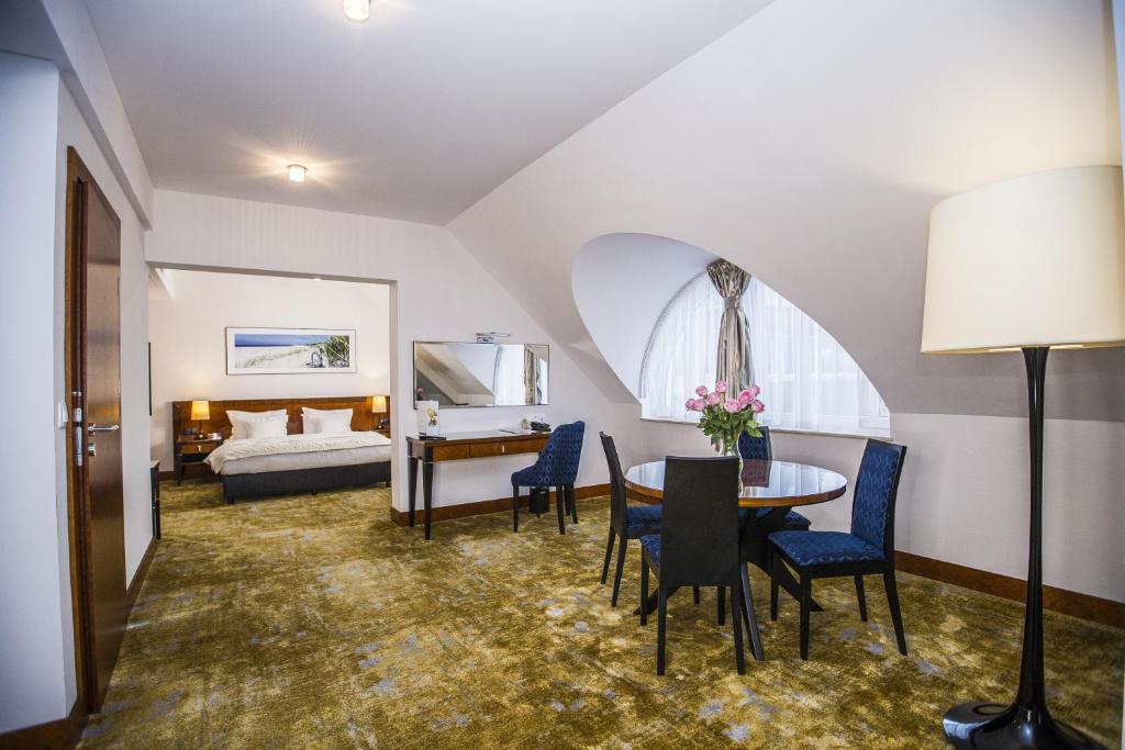 a living room with a bed and a table and chairs at Grand Lubicz Uzdrowisko Ustka in Ustka