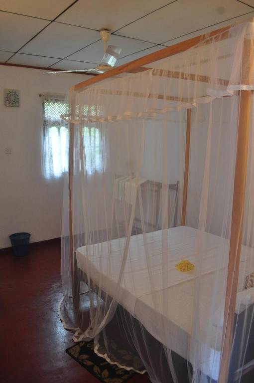 una habitación con una mesa con cortinas. en Sea Breeze Inn Talalla en Talalla South