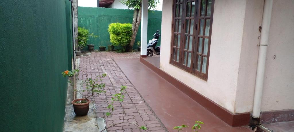 an alley with a green and white building and a plant at The Home in Weligama