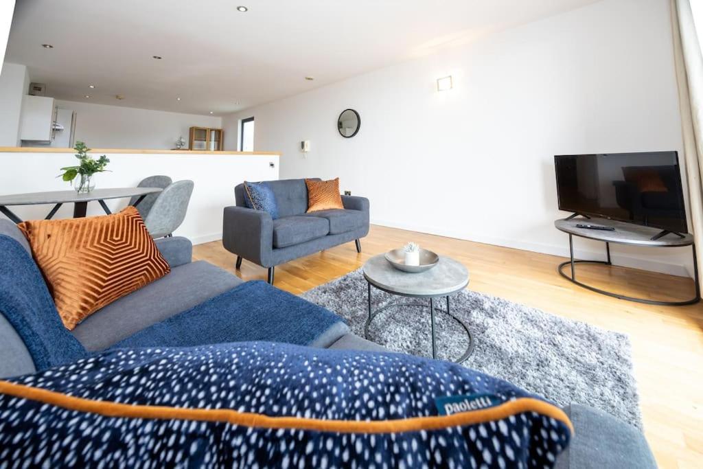 a living room with a blue couch and a tv at Stunning Duplex Apartment, Free Parking For 2, WI-FI, Central Location, Long Term Disc in Manchester