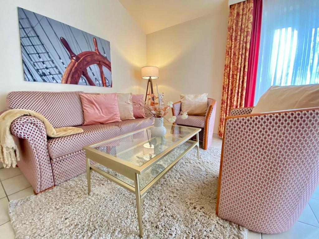 a living room with a couch and a glass coffee table at Residenz Bleichröder - Ferienwohnung Antoinette in Heringsdorf