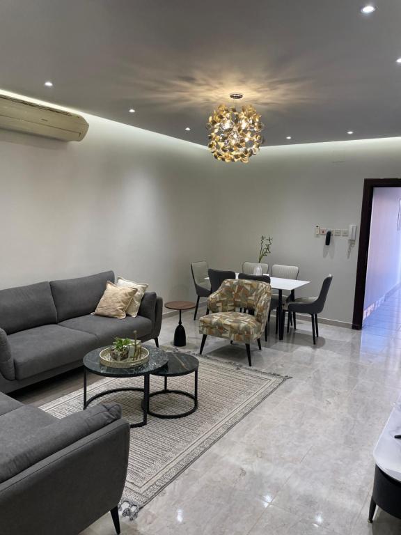 شقة فاخرة ثلاث غرف نوم دور ارضي مع فناء خارجي وباركنج سيارة في Riyadh Al Khabra: غرفة معيشة مع أريكة وكراسي وطاولة