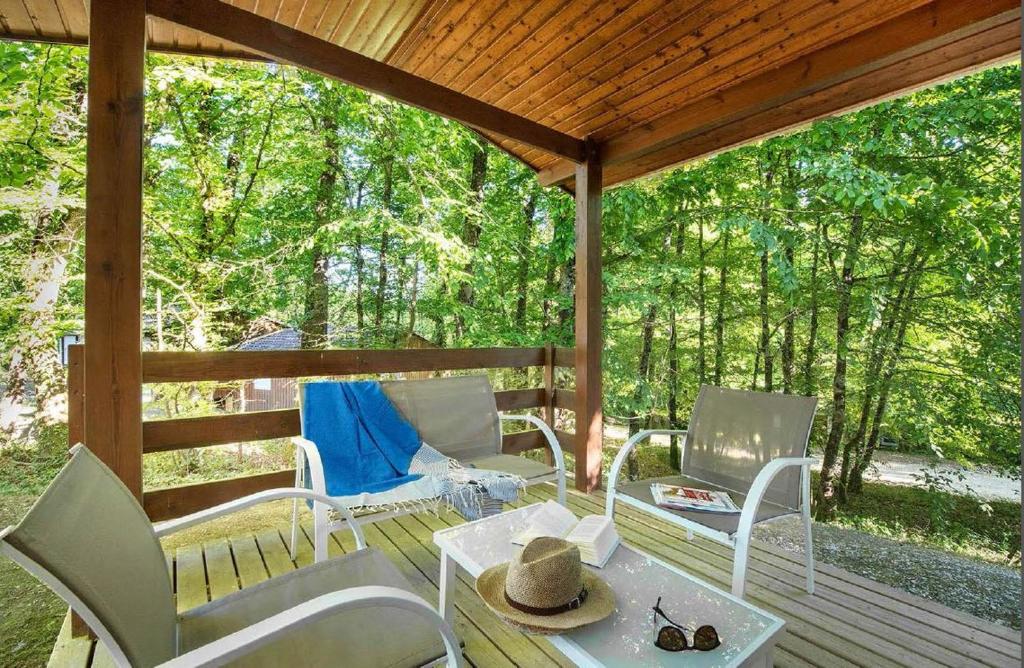 - une terrasse couverte avec des chaises et une table dans l'établissement LE HAMEAU DES ETOILES, à Fleurance