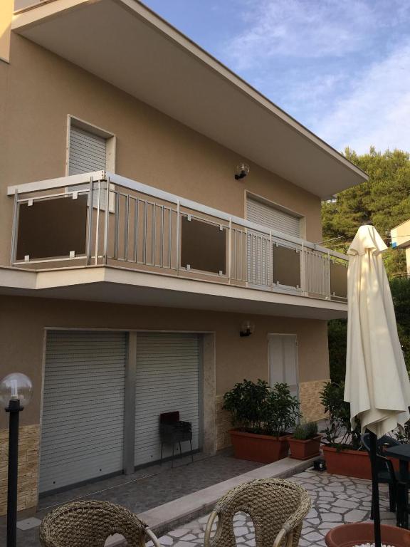 una casa con balcone e ombrellone di Appartamenti in Villa a Pulsano