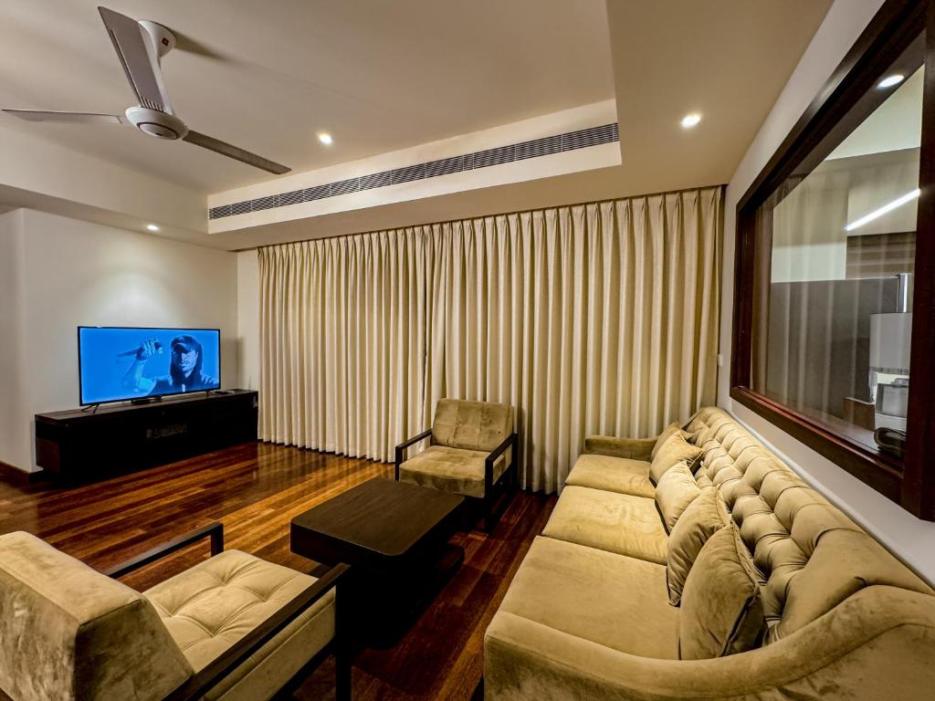 a living room with a couch and a flat screen tv at Brand new Water Front Luxury Cinnamon Suites Apartment in heart of Colombo City in Slave Island