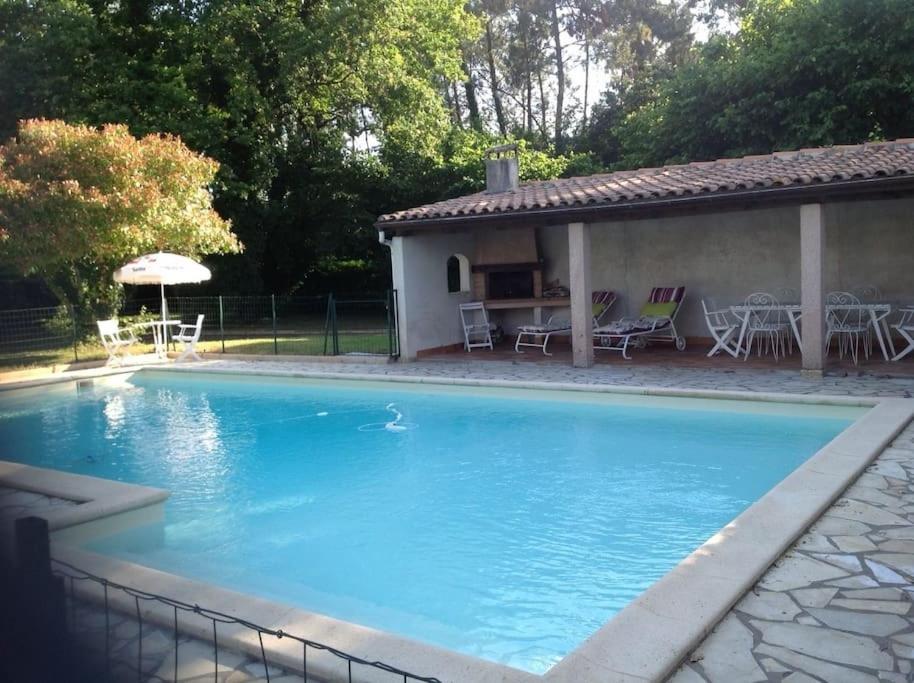 uma grande piscina azul ao lado de uma casa em villa familiale de caractere em Casteljaloux