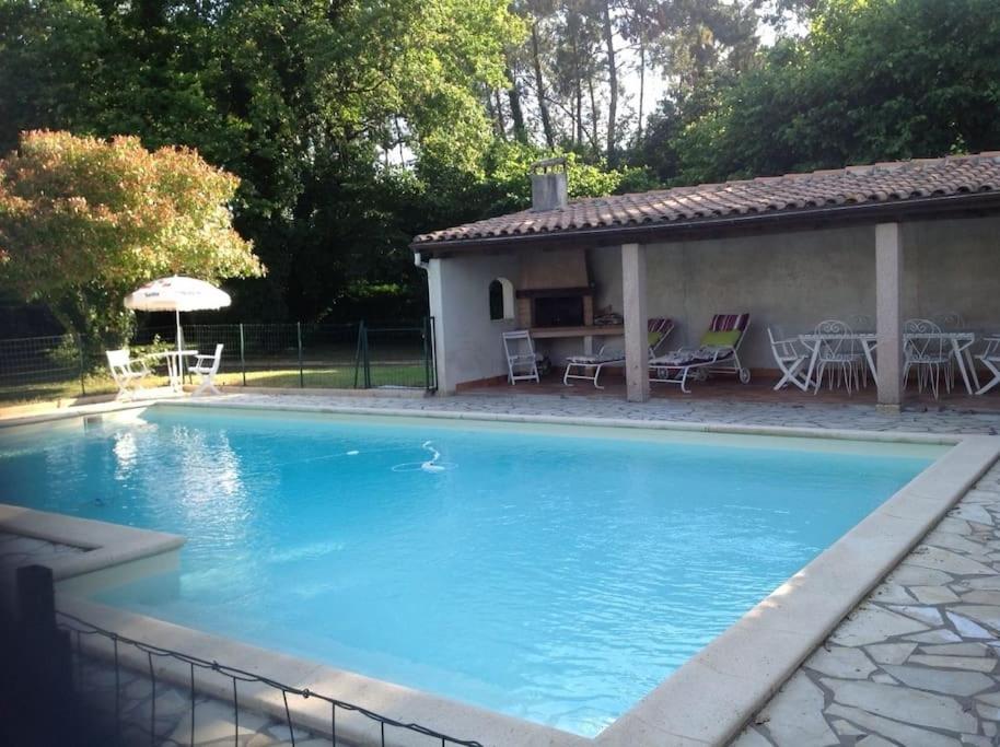 une grande piscine bleue à côté d'une maison dans l'établissement villa familiale de caractere, à Casteljaloux