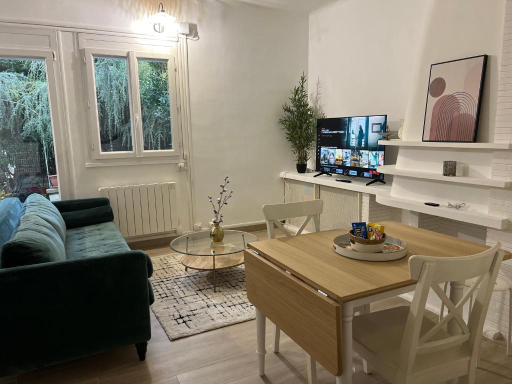 a living room with a couch and a table at Charmant Cocon en duplex avec jardin in Noisy-le-Sec