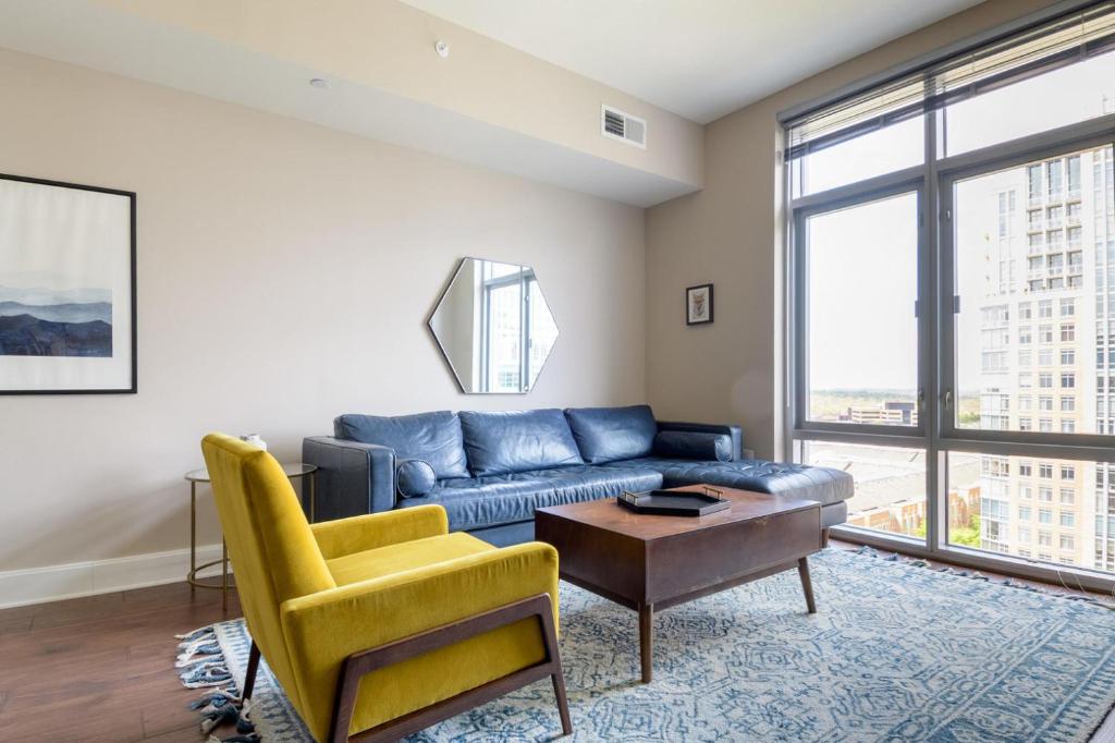 a living room with a blue couch and a table at Reston 2br steps to mall hospital restaurants WDC-832 in Reston