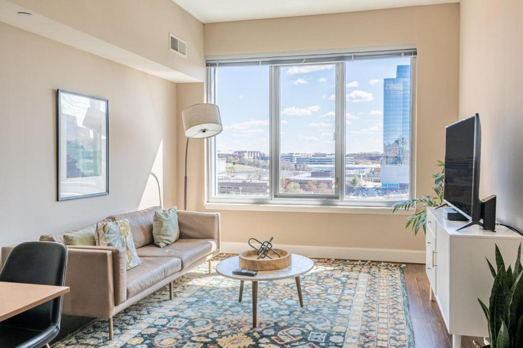 een woonkamer met een bank en een tv bij Reston 2br w pool gym nr dining drinks WDC-830 in Reston