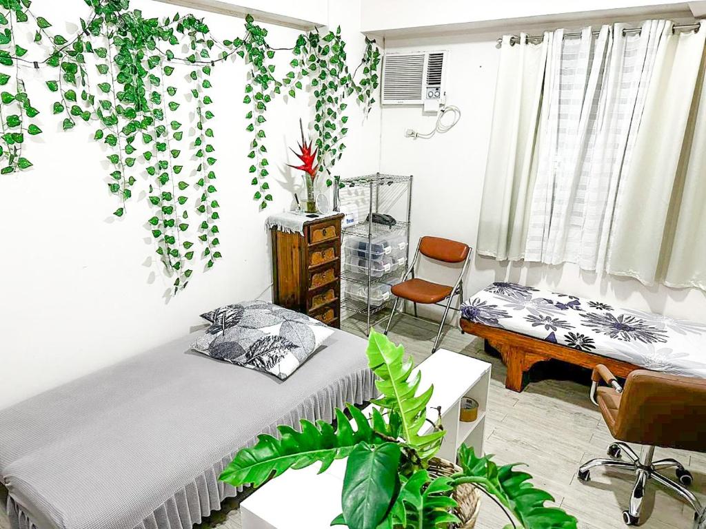 a bedroom with a bed and a desk with a plant at Affordable Condo beside Ayala Mall Bacolod! in Bacolod