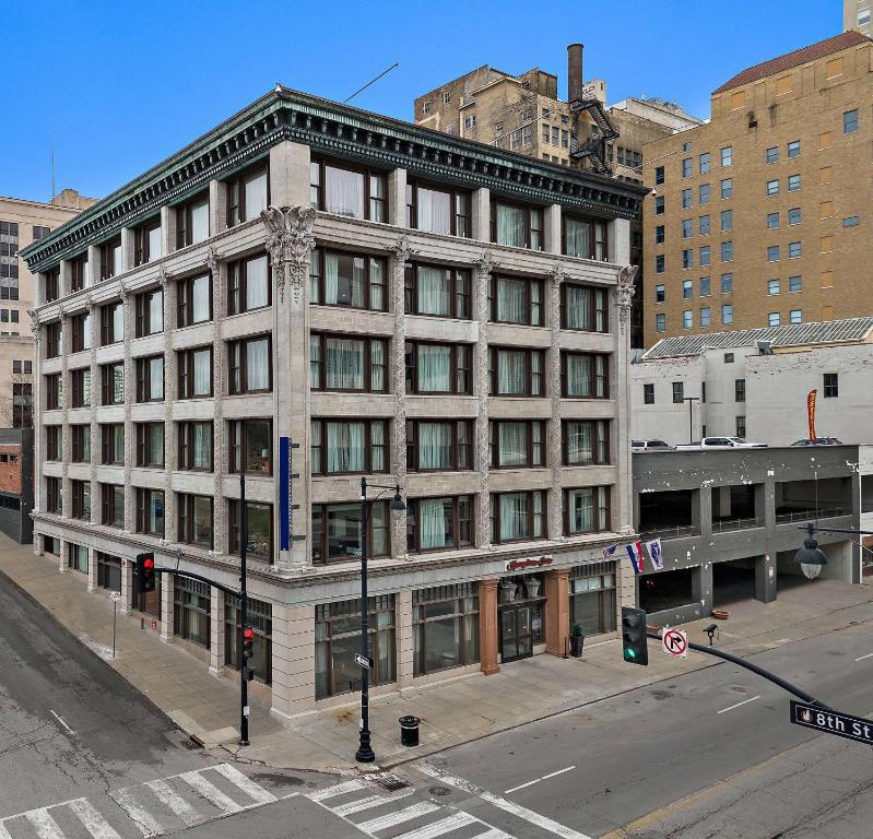 een hoog gebouw in een stadsstraat met een straatbord bij Hampton Inn Kansas City - Downtown Financial District in Kansas City