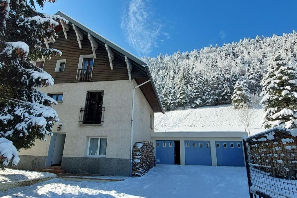 ein Haus mit einem schneebedeckten Dach und einer Garage in der Unterkunft Belle maison de 140 m2 in Villard-de-Lans