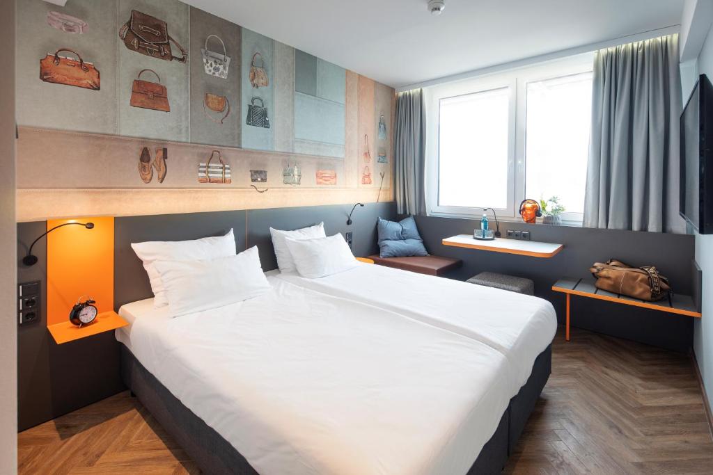 una camera d'albergo con un grande letto e un lavandino di LOGINN Hotel Offenbach a Offenbach