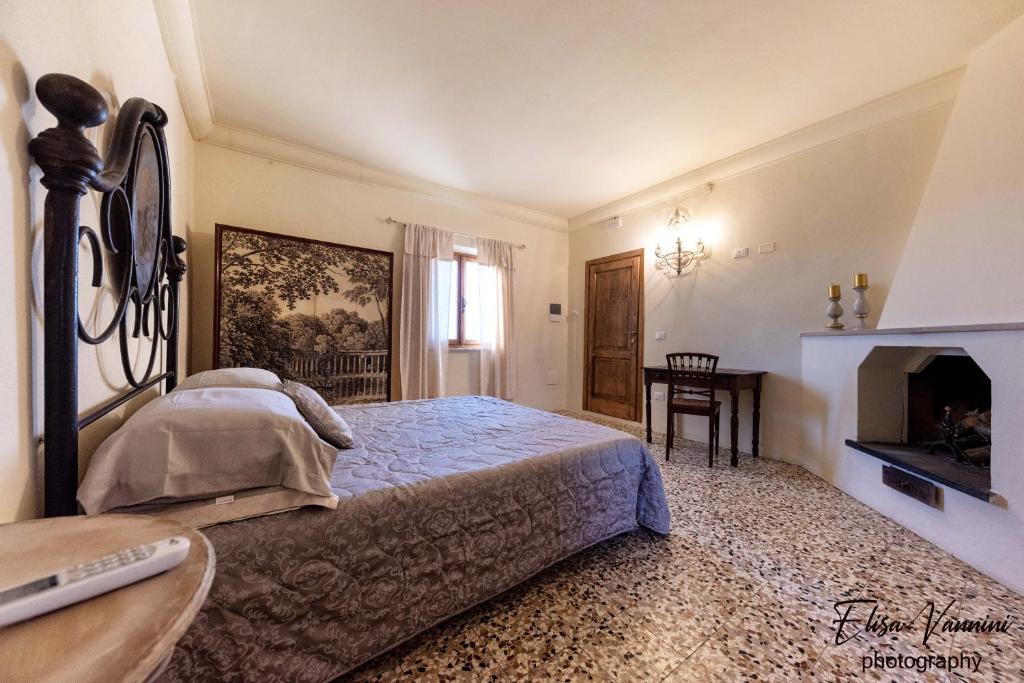 um quarto com uma cama grande e uma lareira em Camere 4 stagioni Agriturismo Vialto em Forcoli