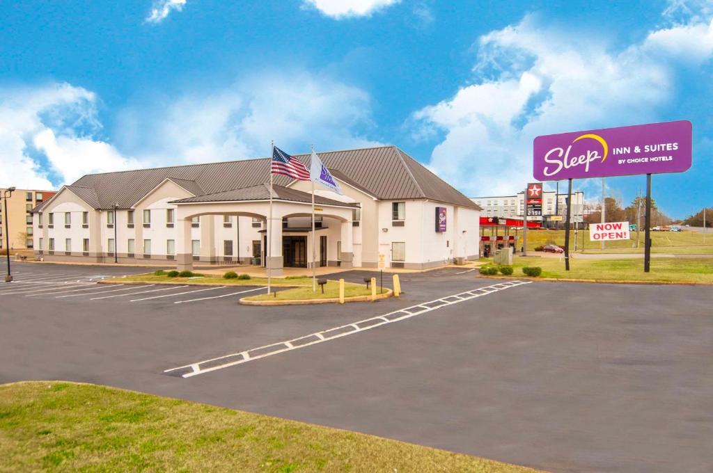 un edificio con un cartel en un estacionamiento en Sleep Inn & Suites, en Tuscaloosa