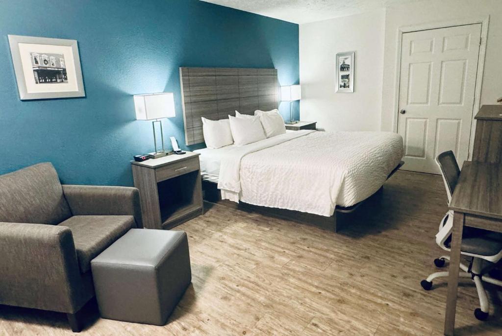 une chambre d'hôtel avec un lit et une chaise dans l'établissement Ramada by Wyndham Lumberton, à Lumberton