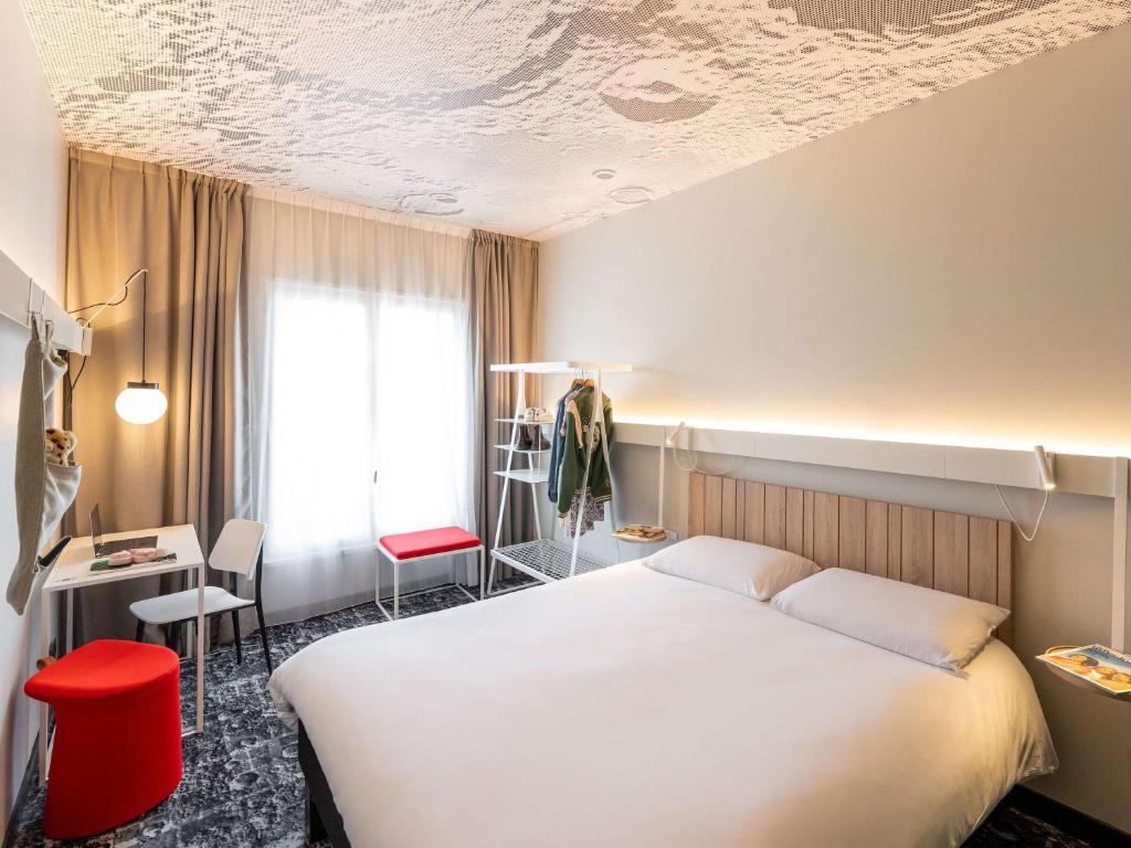 Habitación de hotel con cama, escritorio y ventana en ibis Lyon Centre Perrache, en Lyon