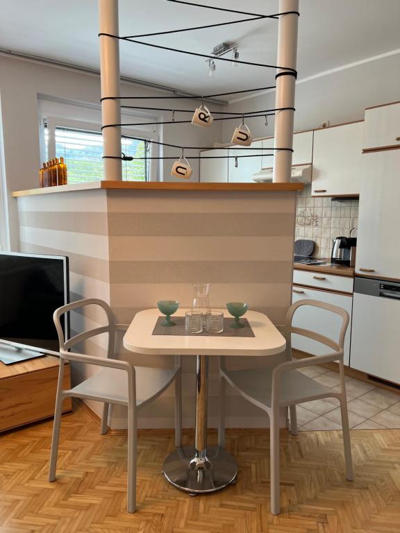uma cozinha com mesa e cadeiras num quarto em Der Landsitz em Klagenfurt