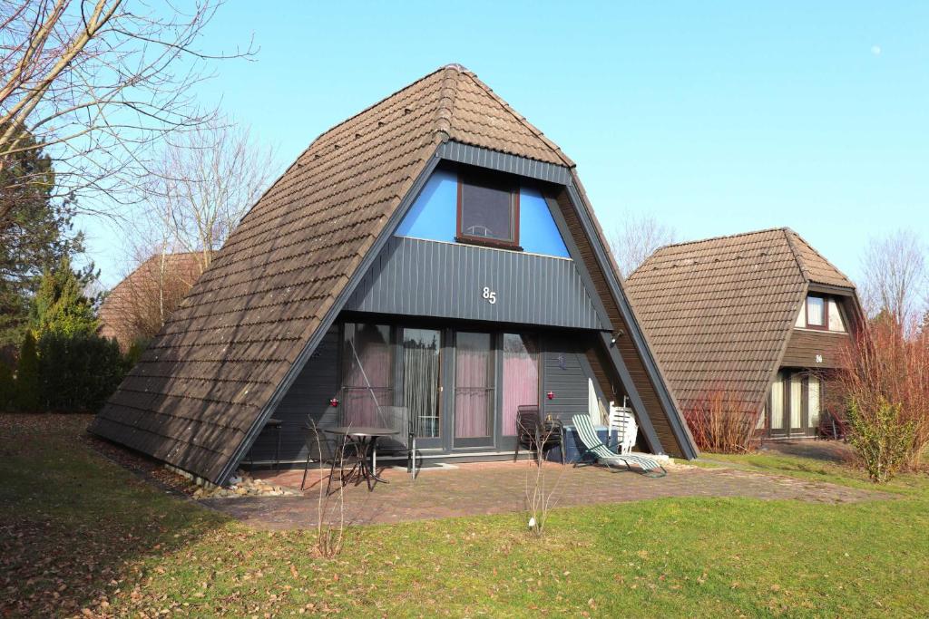 ein Haus mit einem großen Fenster und einem Dach in der Unterkunft Ferienhaus Winnetou Schwarzkittelpfad 85 in Waldbrunn