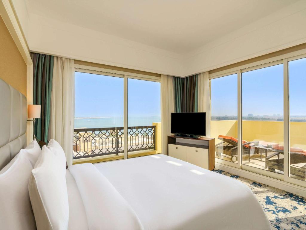 a hotel room with a bed and a television at Rixos Bab Al Bahr - Ultra All Inclusive in Ras al Khaimah