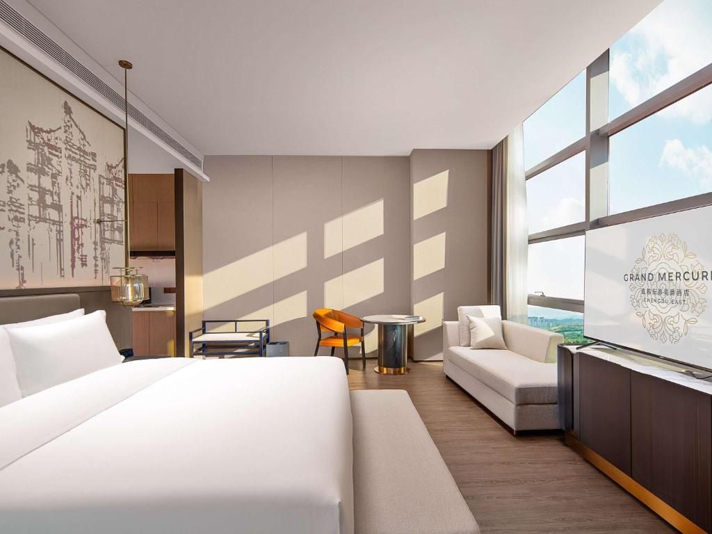 1 dormitorio con 1 cama blanca grande y 1 sofá en Grand Mercure Chengdu East, en Chengdú