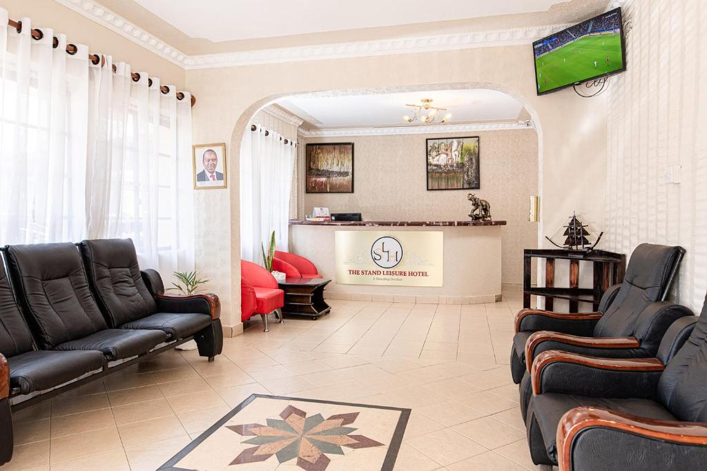 a living room with black leather furniture and a tv at The Stand Leisure Hotel in Nairobi