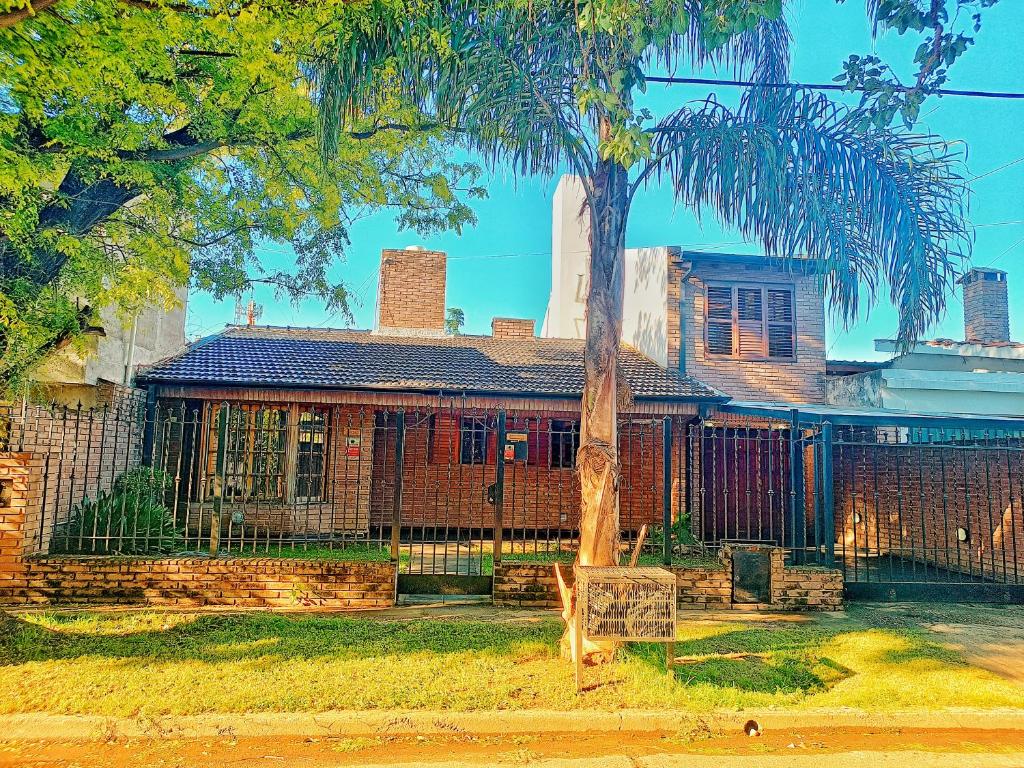 ein Haus mit einer Palme davor in der Unterkunft Casa con quincho y pileta in Cordoba