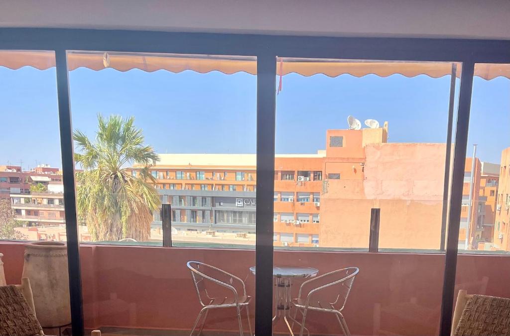 einen Balkon mit Stühlen und Blick auf ein Gebäude in der Unterkunft APPARTEMENT 3 chambres gueliz in Marrakesch