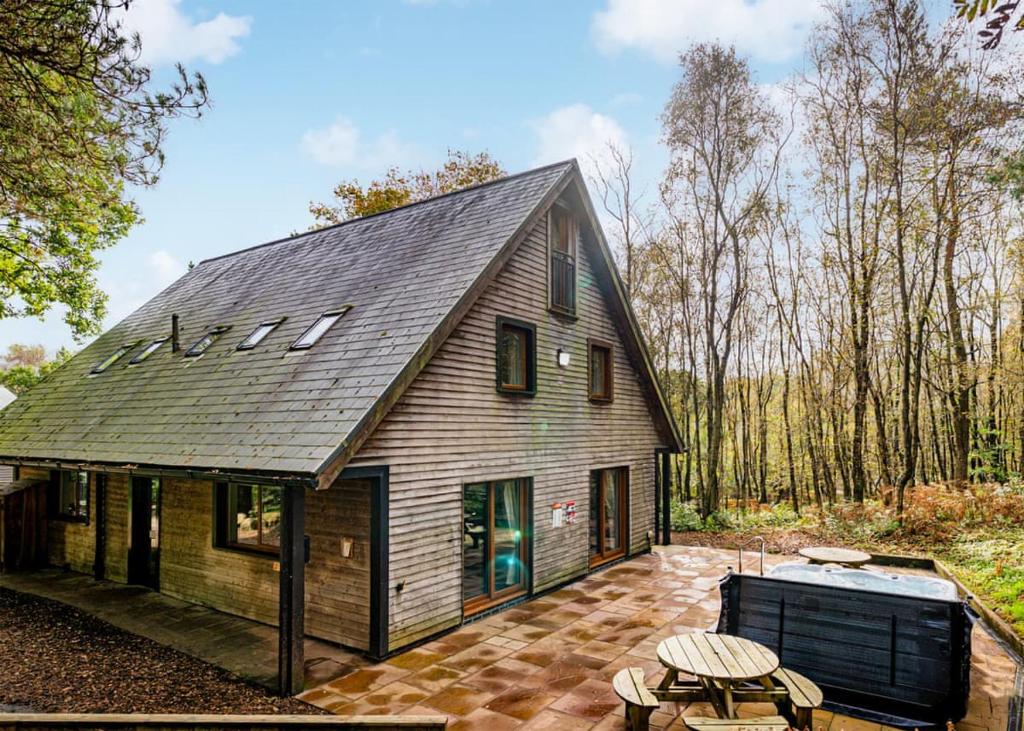 a barn style house with a gambrel roof at Ramshorn Estate Woodland Lodges in Oakamoor