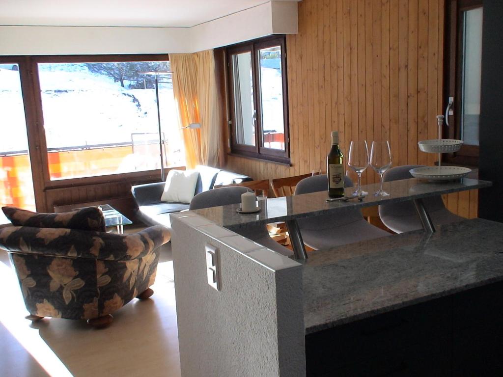 ein Wohnzimmer mit einem Tisch und einer Flasche Wein in der Unterkunft Relax aux Paccots : été comme hiver in Les Paccots