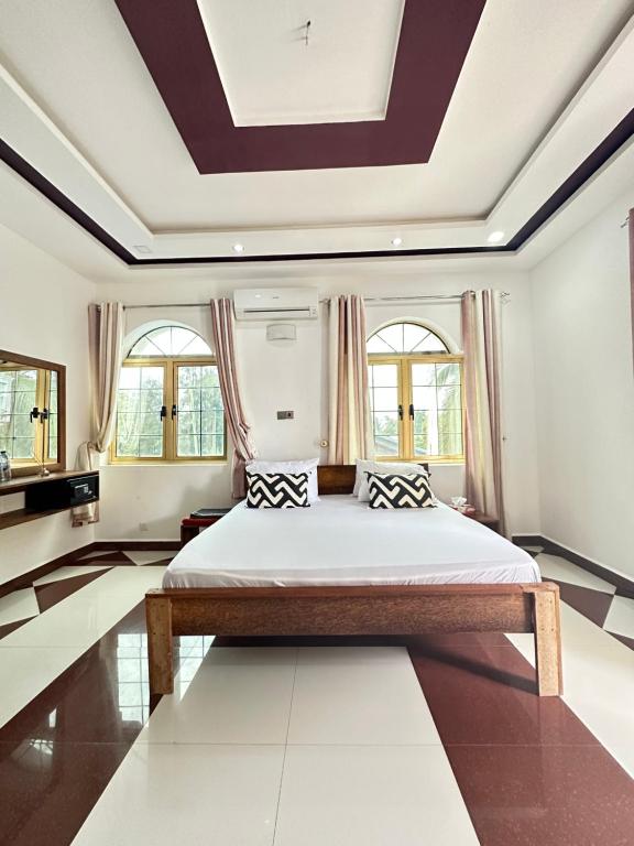1 dormitorio con 1 cama grande y techo artesonado en Airport Lux Rooms en Kiembi Samaki