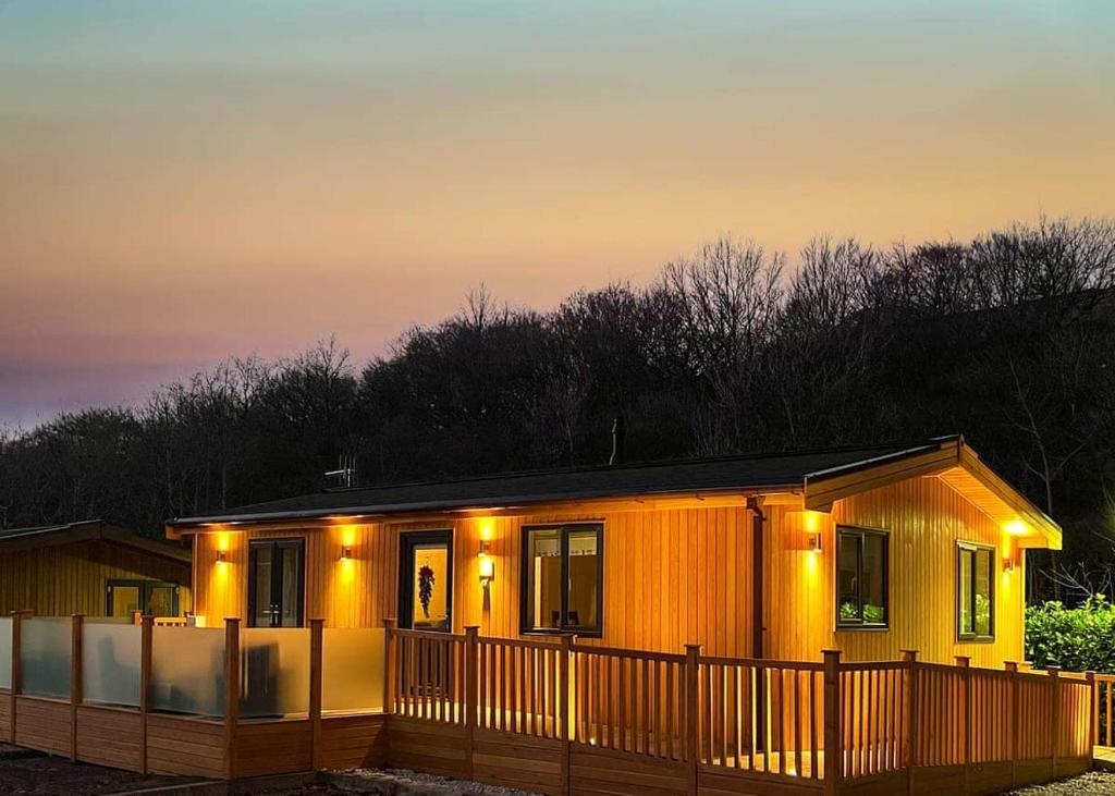 a small wooden house with lights on it at Dovestone Holiday Park in Greenfield