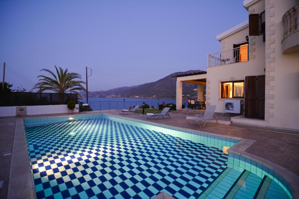 a swimming pool in front of a house at Kalli Villa in Pomos
