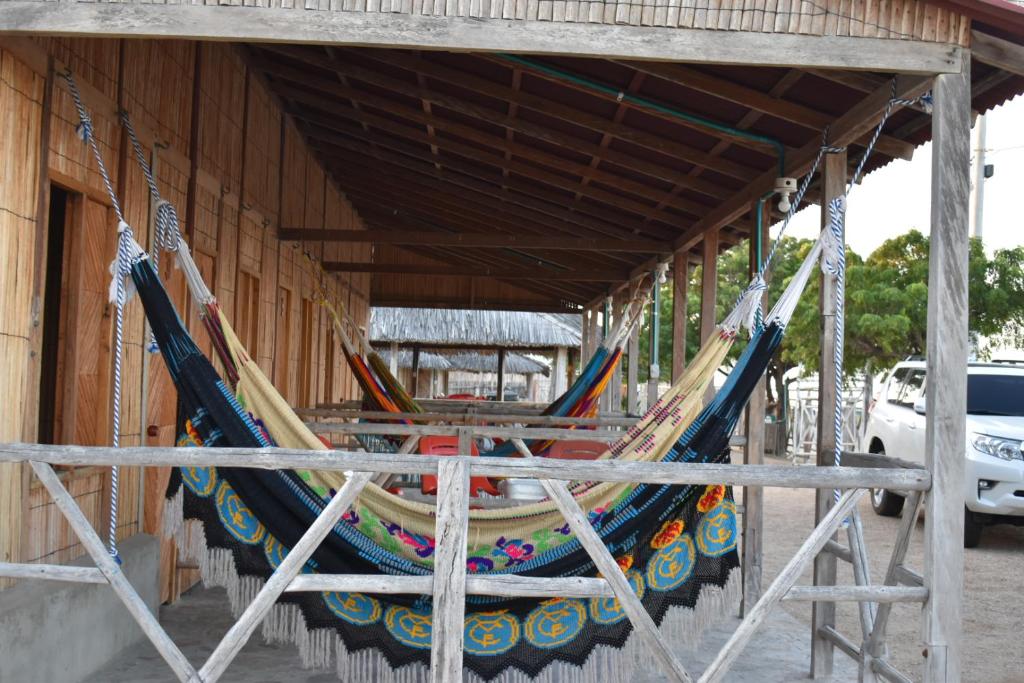 a group of hammocks hanging from a building at El Viejo Moi Hospedaje & Restaurante in Cabo de la Vela