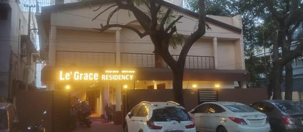 a building with cars parked in front of it at Le Grace Mansion in Madurai
