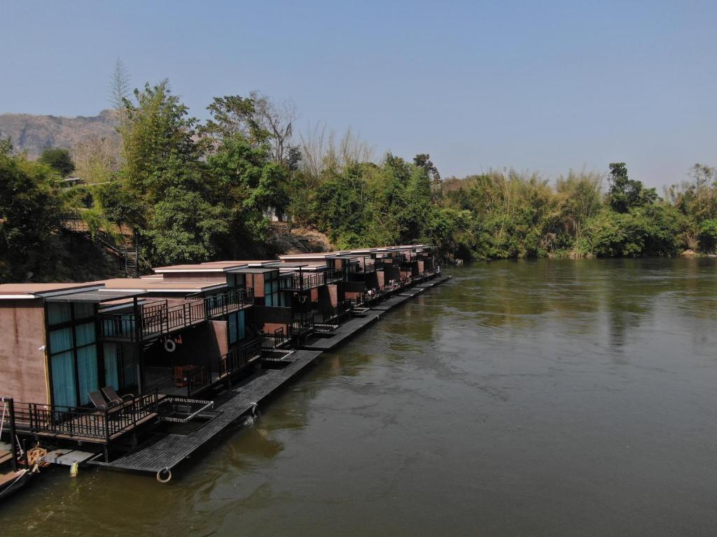 een rij huizen aan de kant van een rivier bij Kwai Tara Riverside Villas in Sai Yok