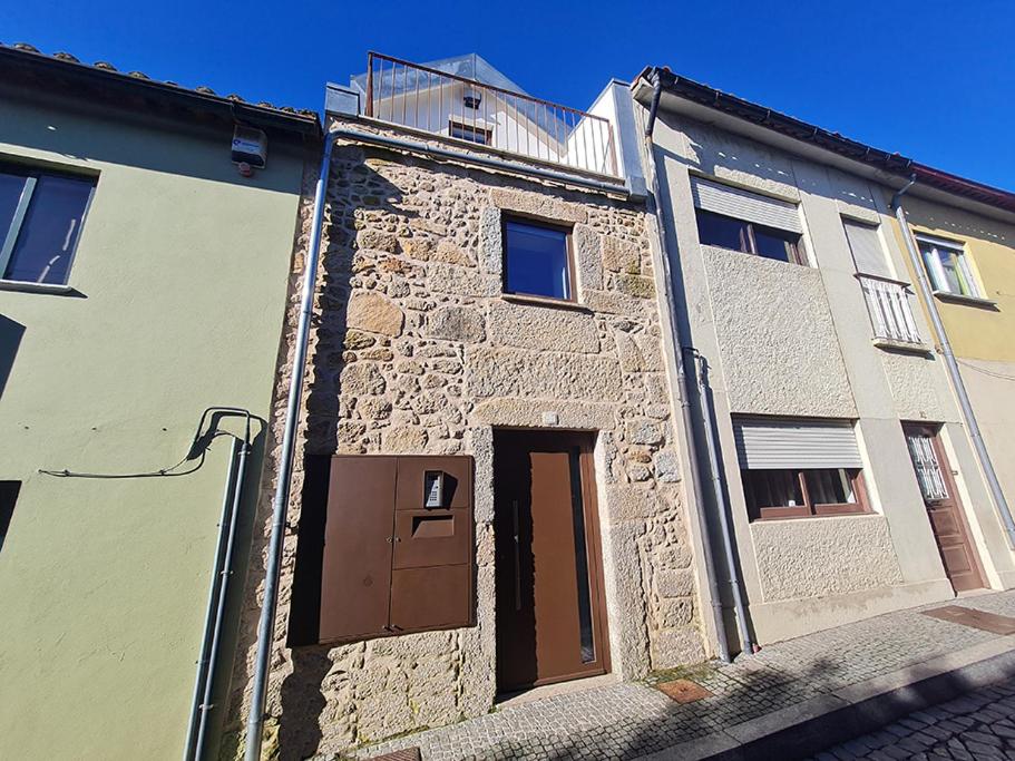 an old stone building with a door on a street at In Barreta in Barcelos