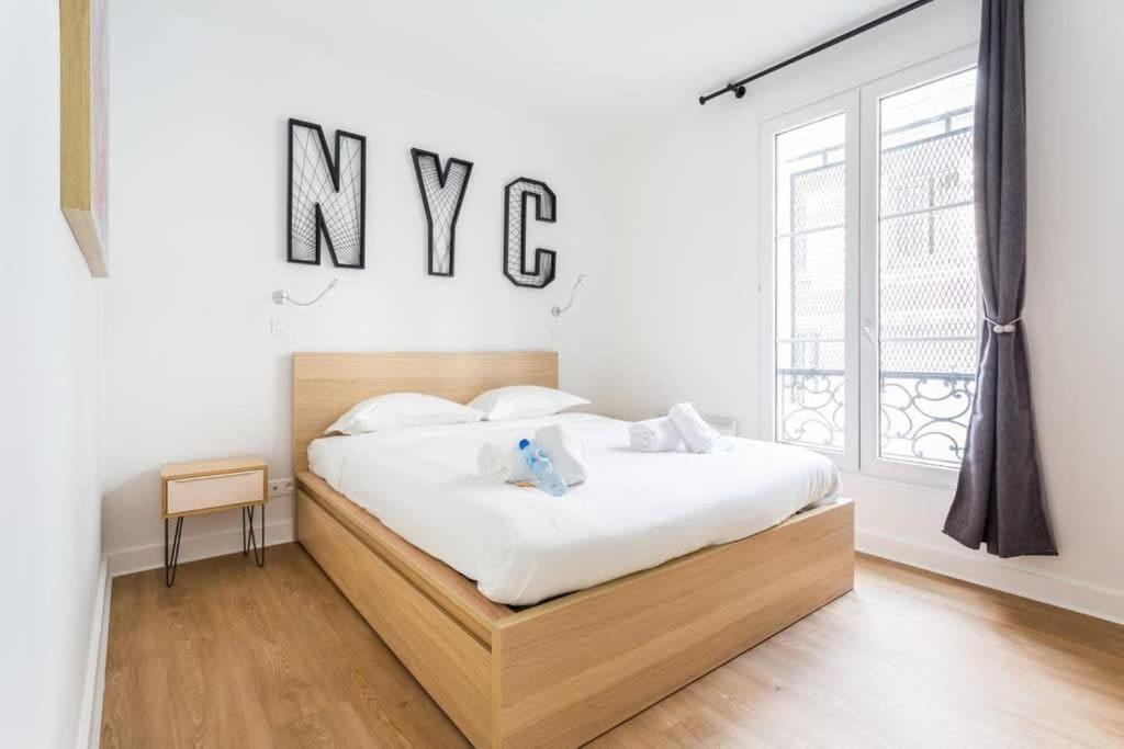 - une chambre avec un lit et un panneau mural dans l'établissement Lemoine/Reaumur 1: Cosy Appartement 4P-1BR, à Paris