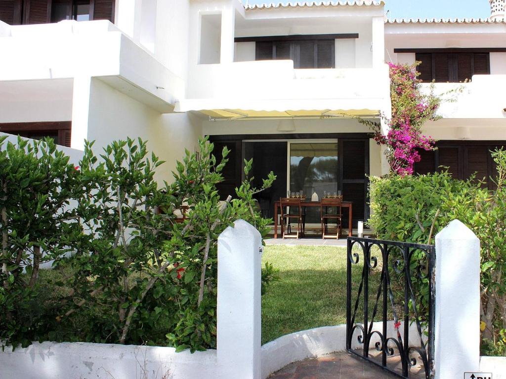una casa blanca con una puerta delante de un patio en Villa Vale Garrão en Almancil