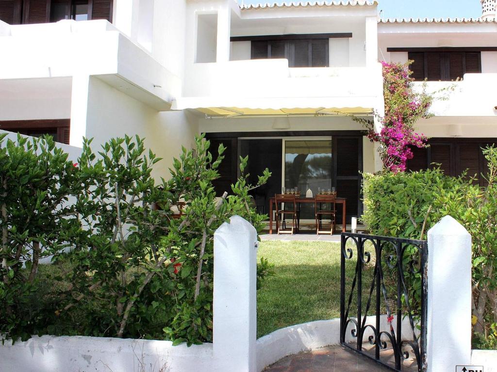 a white house with a gate in front of a yard at Villa Vale Garrão in Almancil