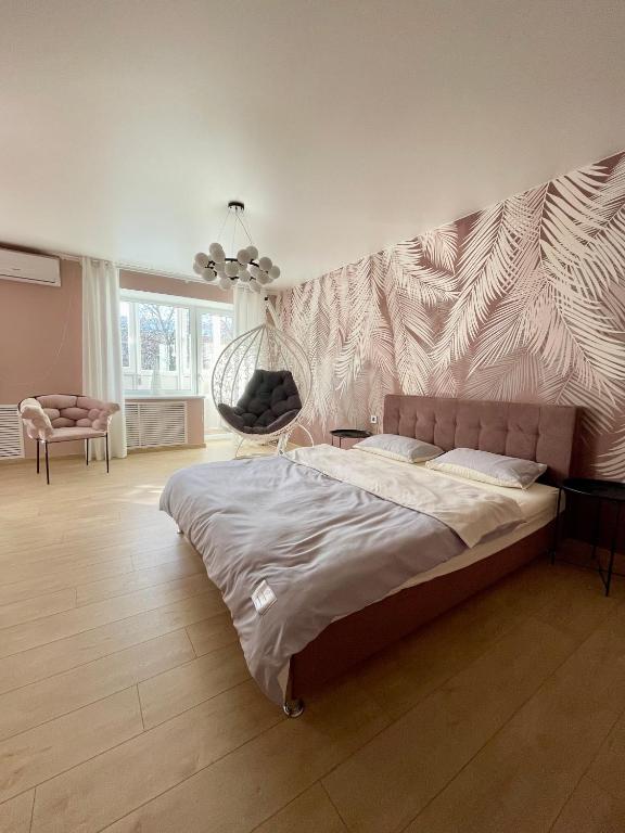 sypialnia z dużym łóżkiem i krzesłem w obiekcie Квартира Тропики центр міста st Remisnycha 55a w mieście Czernihów
