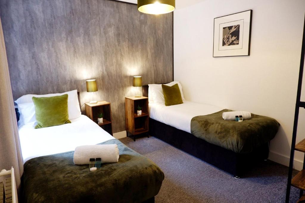 um quarto de hotel com duas camas e dois pufes em COSY 2 Bed APARTMENT NEARBY TRAIN STATION! em Watford