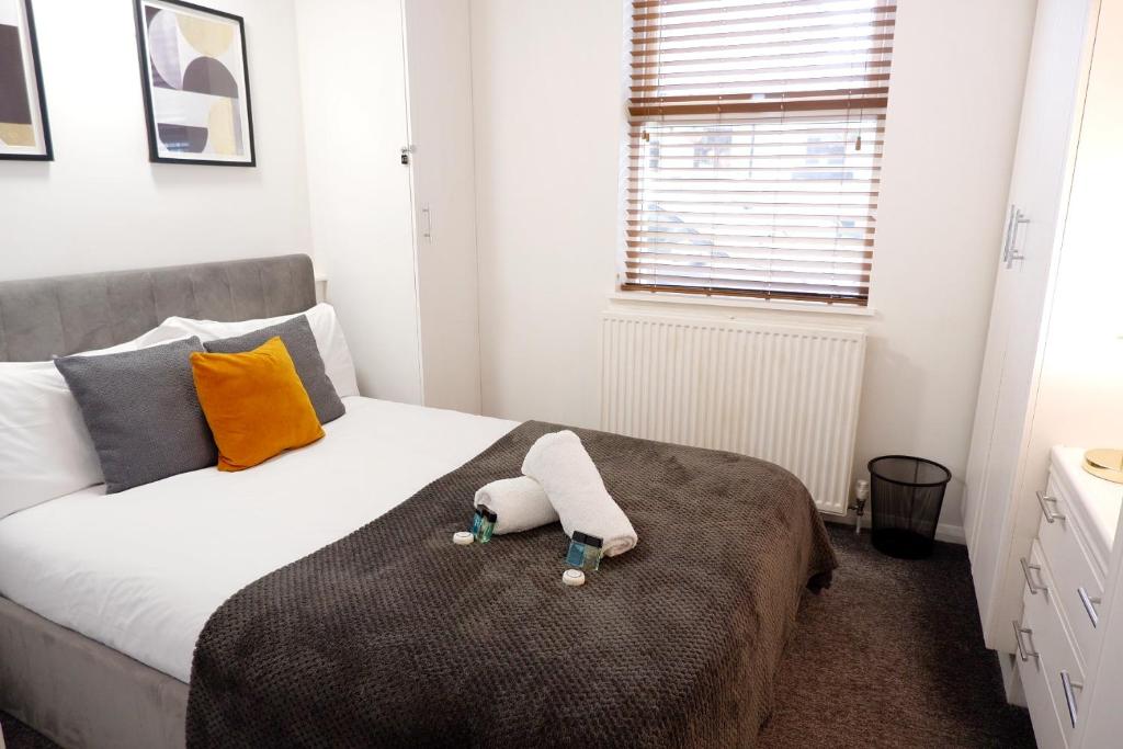 a bedroom with a bed with a stuffed animal on it at COSY 2 Bed APARTMENT NEARBY TRAIN STATION! in Watford