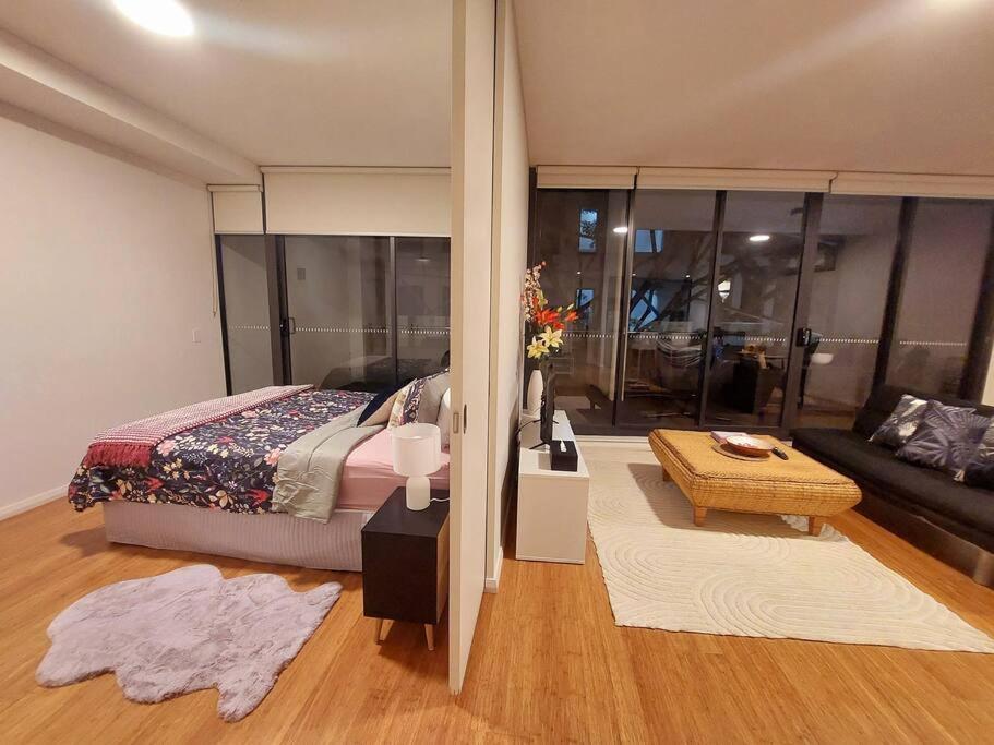 a bedroom with a bed and a living room with a couch at Stylish 1 bedroom best location in Sydney