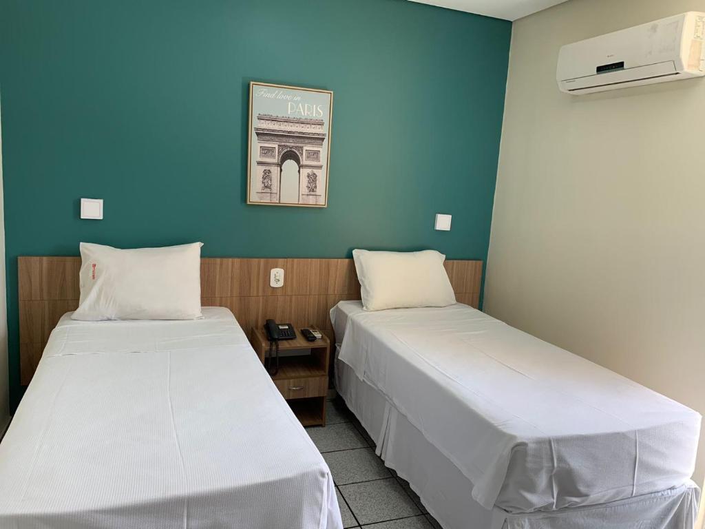 2 Betten in einem Zimmer mit blauer Wand in der Unterkunft Boulevard Park Hotel in São Luís