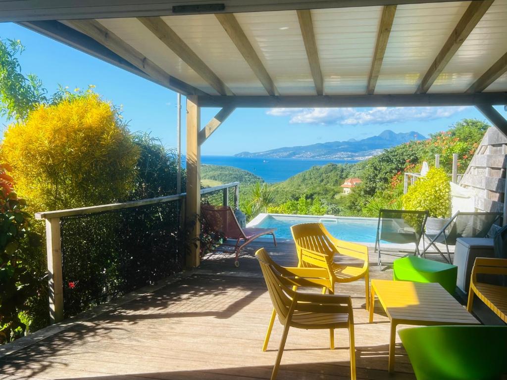 un patio con sillas y vistas al agua en Villa Fresh&Cosy Trois-Ilets 3 étoiles en Les Trois-Îlets
