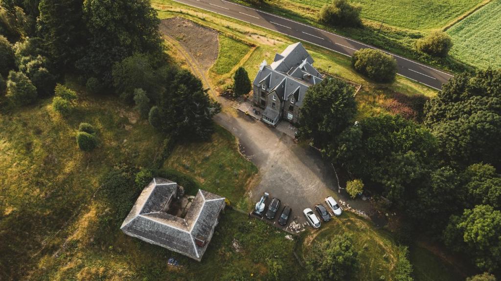 une vue aérienne sur une maison avec un groupe de voitures garées dans l'établissement Suie Hunting Lodge, à Killin